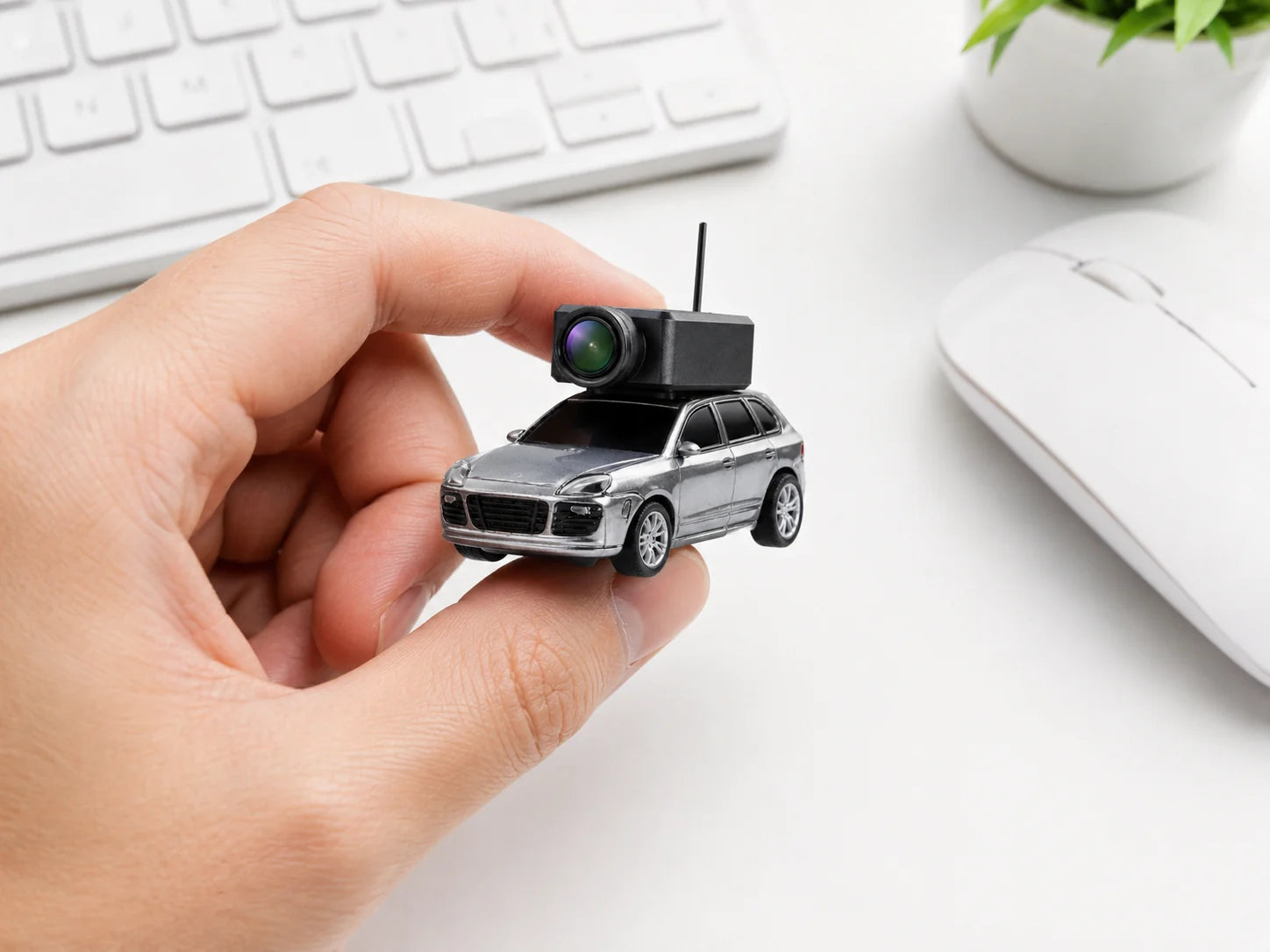 Pocket FPV Camera Car held between two fingers to show its miniature scale